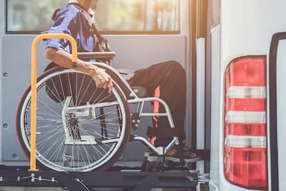 Older man boarding bus on wheelchair lift